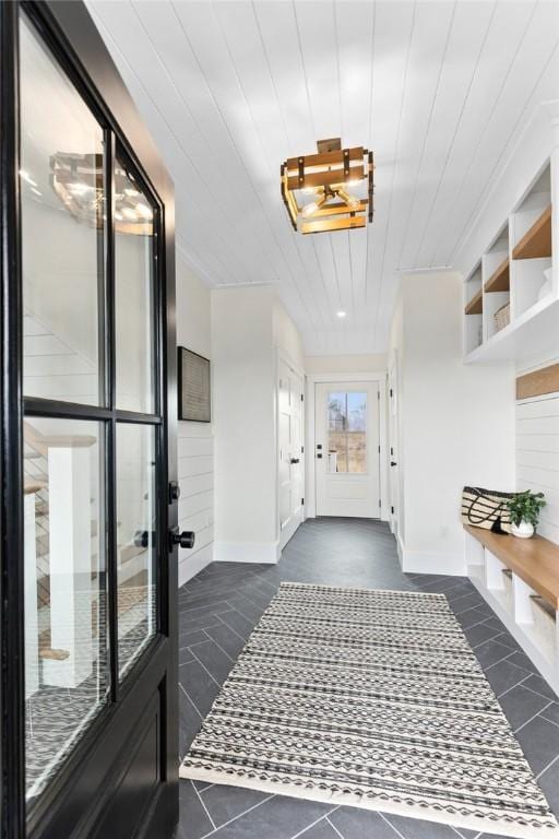 interior space featuring dark tile patterned flooring and wood ceiling