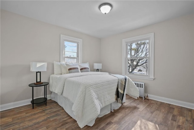 bedroom with radiator heating unit and dark hardwood / wood-style floors