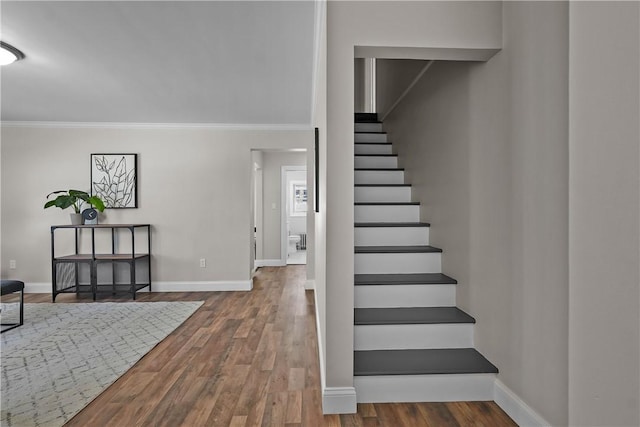 stairway with crown molding and hardwood / wood-style floors