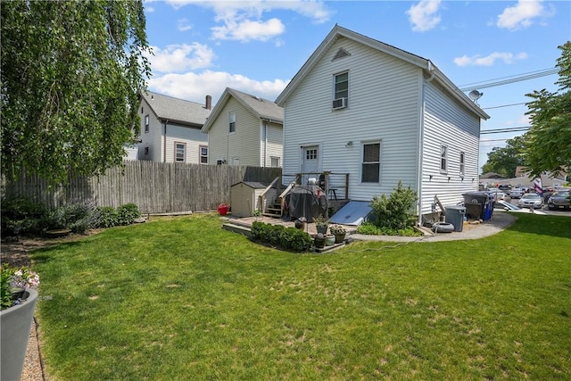 rear view of house with a yard and a shed