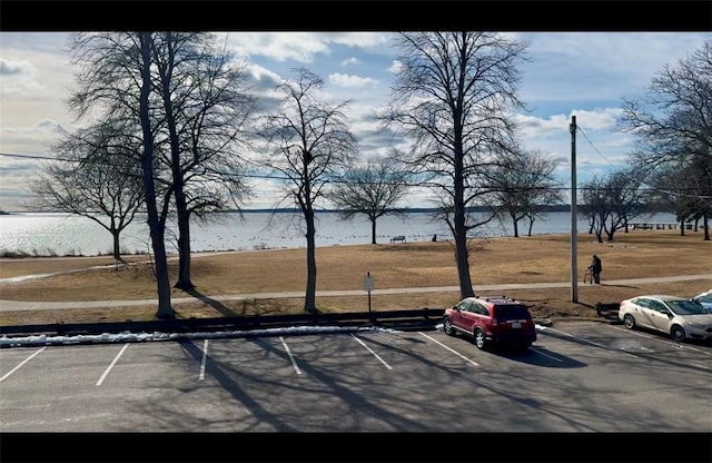 view of parking / parking lot with a water view