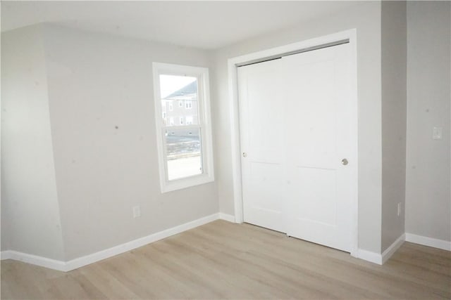 unfurnished bedroom featuring light hardwood / wood-style flooring and a closet