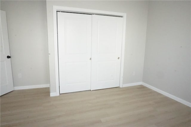 unfurnished bedroom featuring light hardwood / wood-style floors and a closet