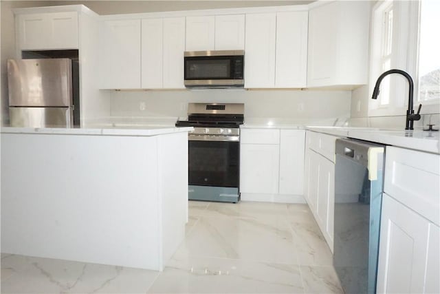 kitchen with white cabinetry, stainless steel appliances, and sink