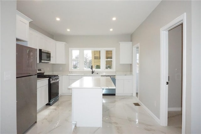 kitchen with appliances with stainless steel finishes, a center island, sink, and white cabinets