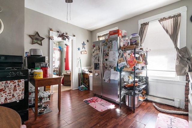 interior space featuring dark wood-type flooring, a baseboard radiator, and black range with gas stovetop