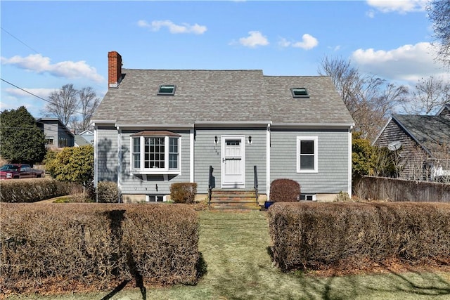 view of front facade featuring a chimney and a shingled roof