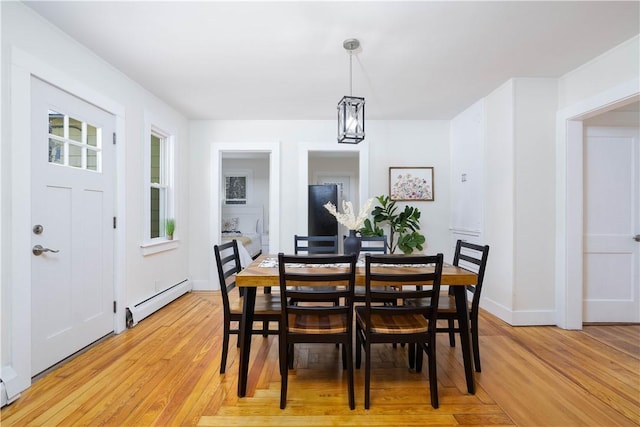 dining space with baseboard heating and light hardwood / wood-style flooring