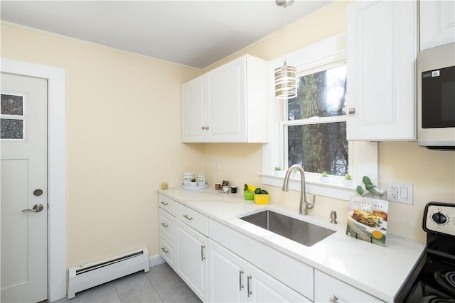 kitchen featuring sink, white cabinetry, decorative light fixtures, appliances with stainless steel finishes, and a baseboard heating unit