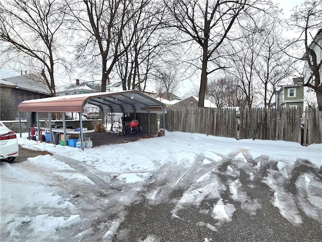 snowy yard featuring a carport