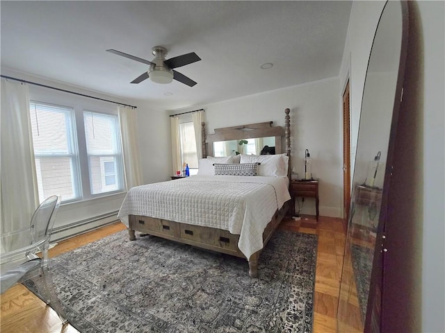 bedroom with parquet flooring, a baseboard heating unit, and ceiling fan