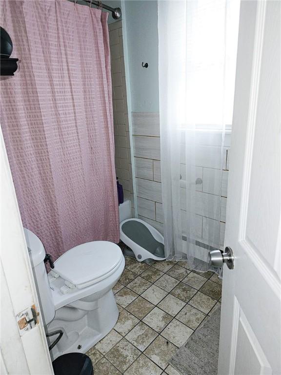 36 Utton Ave, Pawtucket, RI 02860 - full bath with toilet, tile patterned flooring, shower / tub combo, and tile walls
