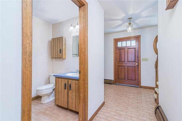 foyer entrance featuring baseboard heating and sink