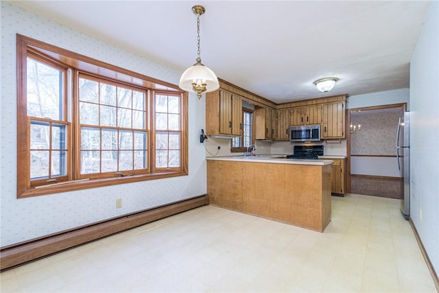 kitchen featuring decorative light fixtures, a baseboard radiator, sink, kitchen peninsula, and stainless steel appliances