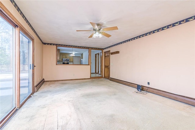 carpeted spare room featuring baseboard heating and ceiling fan