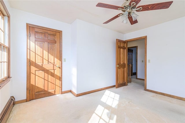 carpeted empty room with ceiling fan and baseboard heating