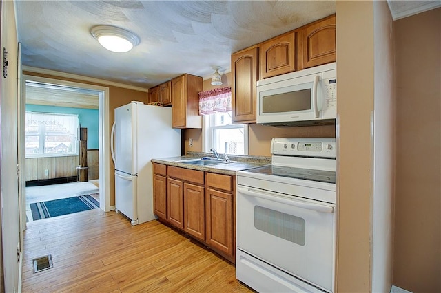 kitchen featuring crown molding, sink, white appliances, and light hardwood / wood-style flooring