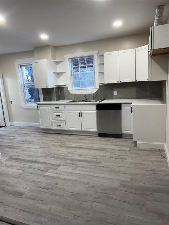 kitchen featuring white cabinetry, dishwasher, sink, and light wood-type flooring