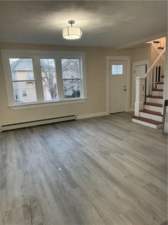 foyer entrance featuring plenty of natural light, light wood-type flooring, and baseboard heating