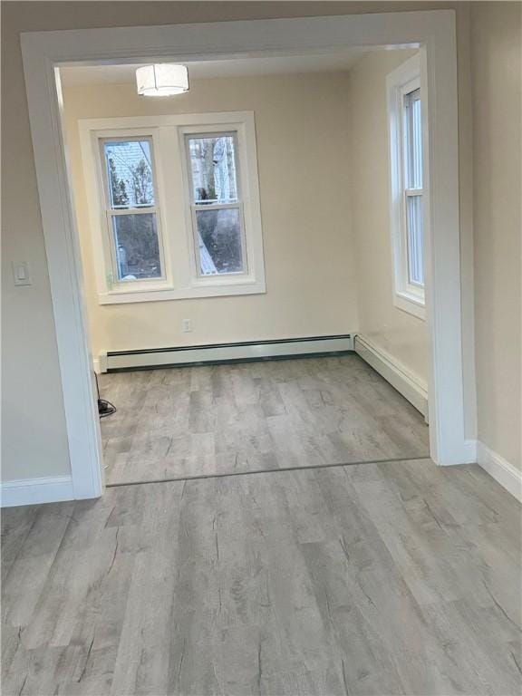 unfurnished dining area featuring light hardwood / wood-style floors and baseboard heating