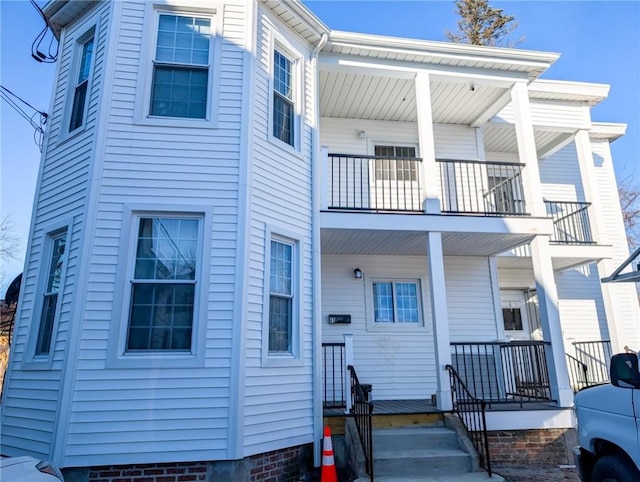 multi unit property featuring covered porch and a balcony