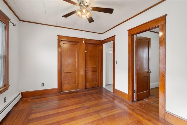 unfurnished bedroom with baseboard heating, ornamental molding, and wood-type flooring