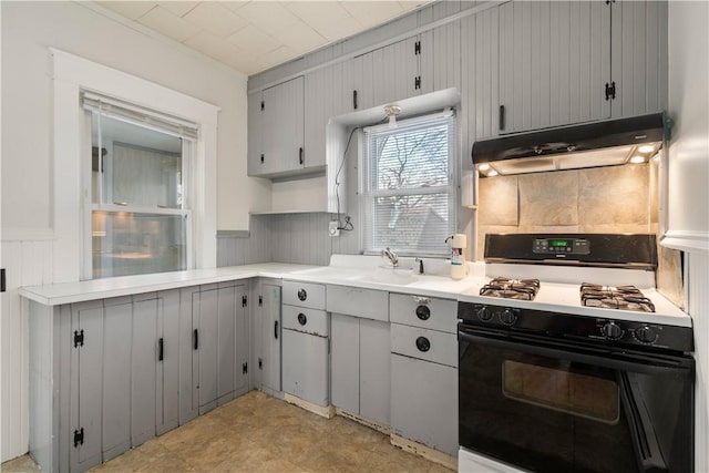 kitchen featuring tasteful backsplash, sink, gray cabinets, and gas stove