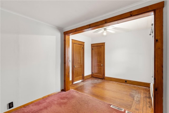 empty room with crown molding, ceiling fan, and light hardwood / wood-style floors