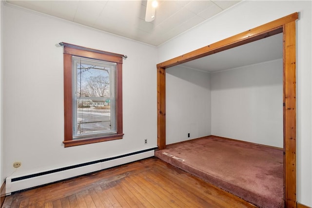 interior space featuring crown molding, dark hardwood / wood-style flooring, and a baseboard heating unit