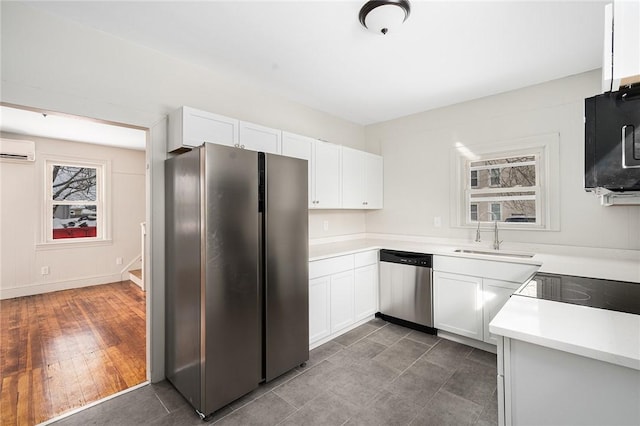 kitchen with sink, a wall mounted air conditioner, white cabinets, and appliances with stainless steel finishes