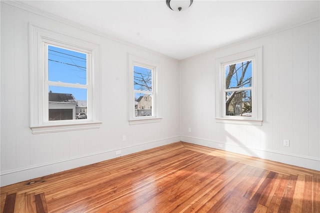 spare room featuring hardwood / wood-style flooring and plenty of natural light