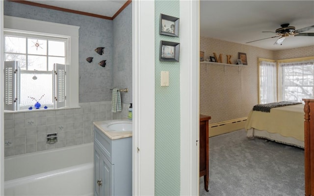 bathroom with vanity, a baseboard radiator, a tub, and plenty of natural light