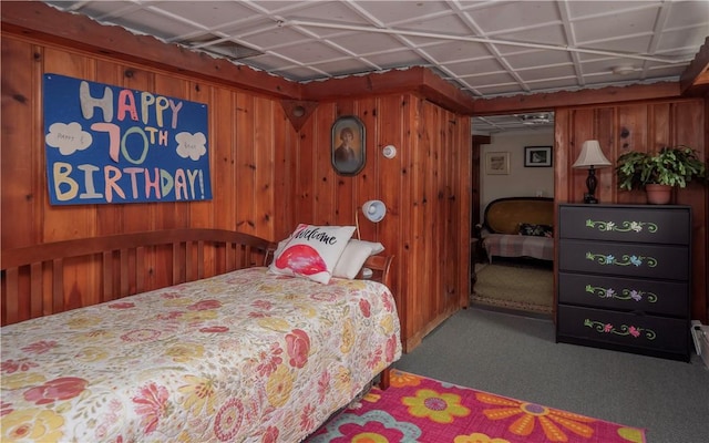 carpeted bedroom with wood walls