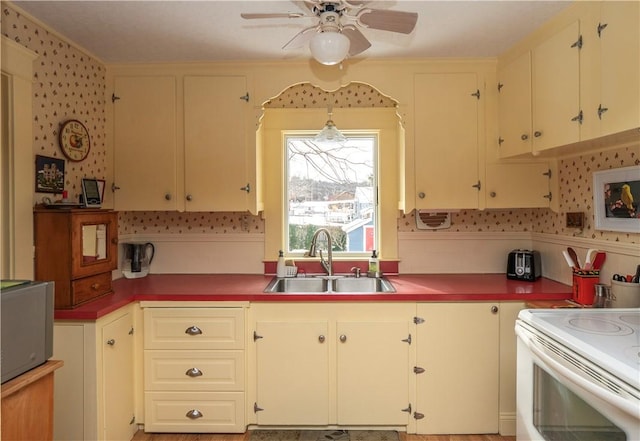 kitchen featuring sink, ceiling fan, and white range with electric cooktop