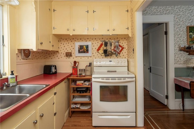 kitchen featuring cream cabinets, sink, dark hardwood / wood-style floors, and electric stove