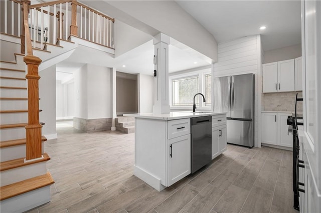 kitchen featuring white cabinetry, a center island, stainless steel fridge, and dishwashing machine