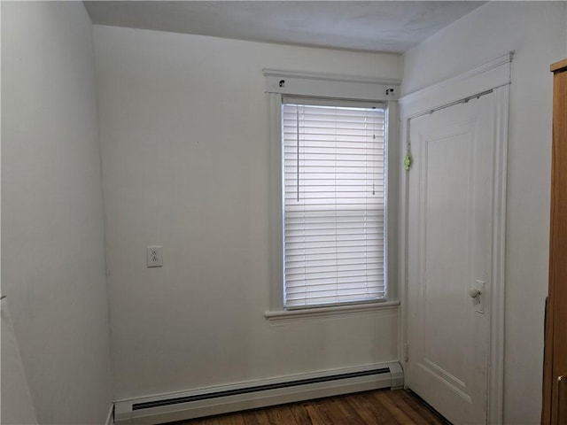 unfurnished room with dark hardwood / wood-style flooring, a wealth of natural light, and a baseboard radiator