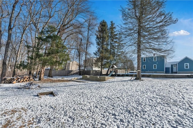 yard covered in snow with a playground