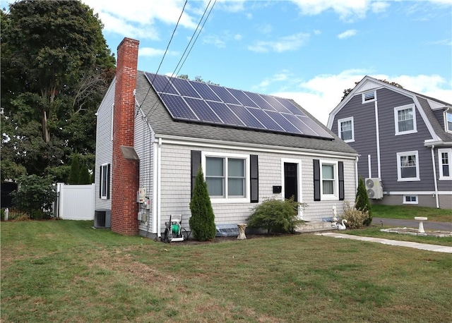 view of front of house with a front yard, central AC unit, and solar panels