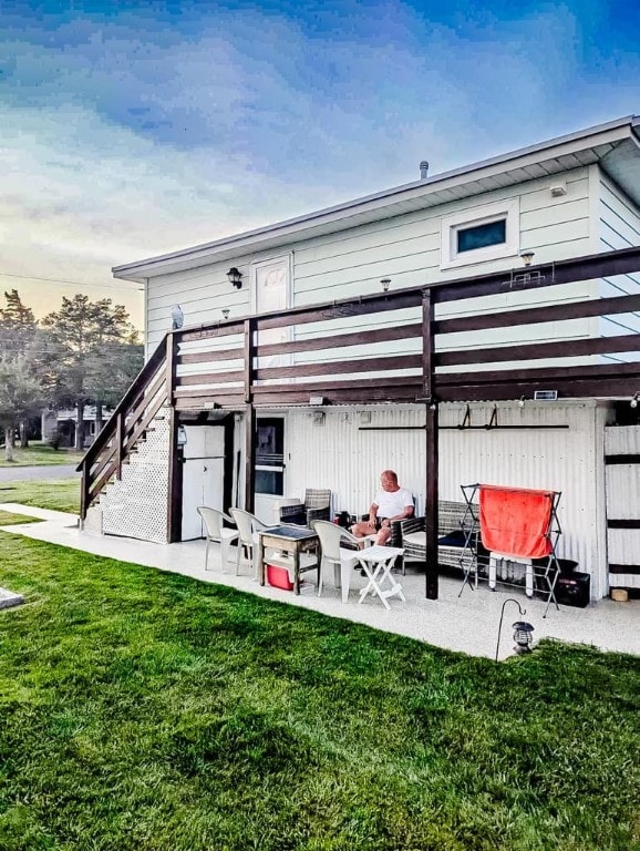 back house at dusk with a yard and a patio