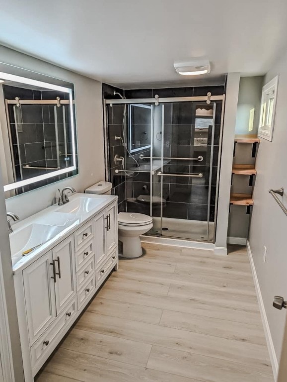 bathroom with walk in shower, vanity, toilet, and hardwood / wood-style floors