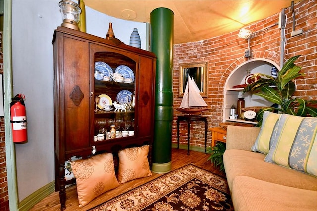 interior space with wood-type flooring and brick wall