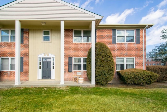 view of front of property featuring a front lawn and brick siding