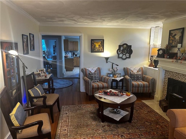 living room with a tile fireplace, crown molding, and wood finished floors