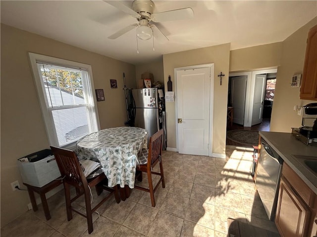 dining room featuring a ceiling fan, baseboards, and light tile patterned floors