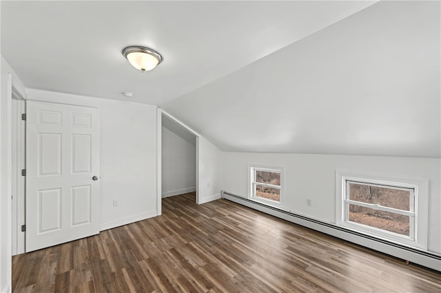 additional living space with vaulted ceiling, dark hardwood / wood-style floors, and baseboard heating