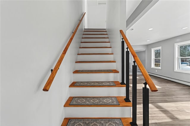 stairway featuring hardwood / wood-style floors and baseboard heating