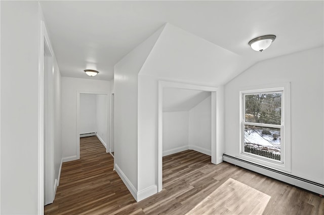 additional living space featuring wood-type flooring, vaulted ceiling, and baseboard heating