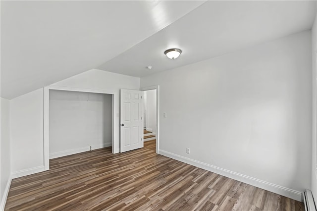 bonus room featuring baseboard heating and dark hardwood / wood-style flooring