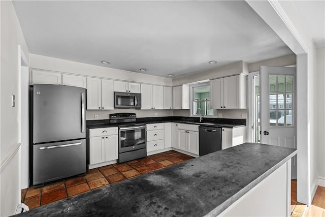 kitchen with dark countertops, recessed lighting, white cabinetry, and appliances with stainless steel finishes